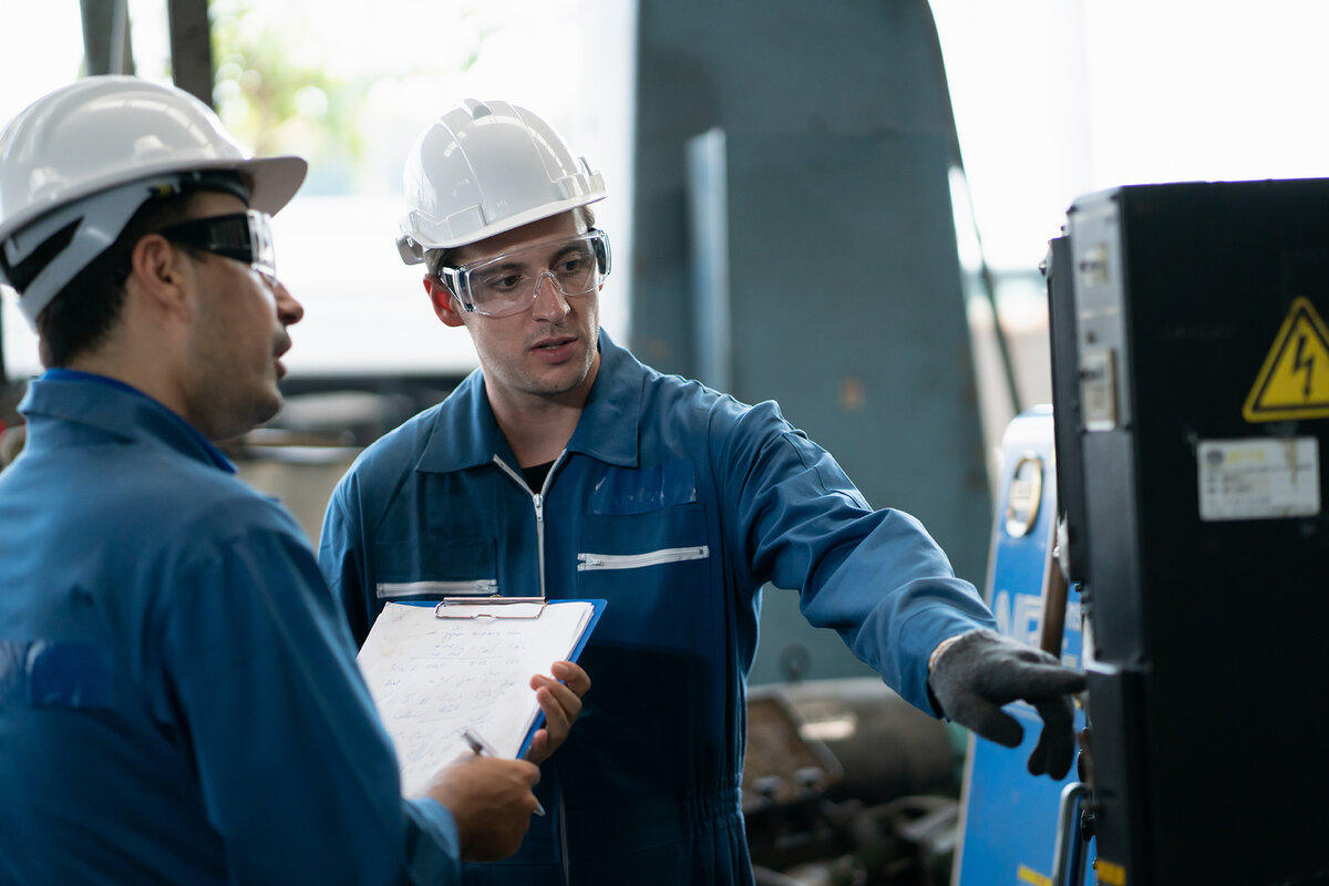 Two manufacturing workers talking in a warehouse factory